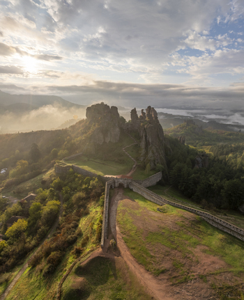 Aerial view of Belogradchik Fortress featuring ancient stone walls and towers nestled among dramatic rock formations illuminated by morning light Belogradchik Vidin Bulgaria. Aerial view of Belogradchik Fortress featuring ancient stone walls and towers nestled among dramatic rock formations illuminated by morning light Belogradchik Vidin Bulgaria.