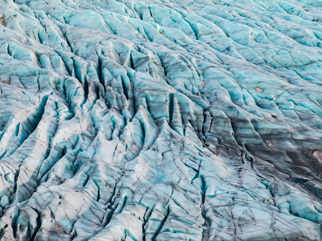 Aerial view of Svinafellsjokull glacier showing deep blue crevasses and intricate ice formations in Sveitarfelagid Hornaf Iceland. Aerial view of Svinafellsjokull glacier showing deep blue crevasses and intricate ice formations in Sveitarfelagid Hornaf Iceland.