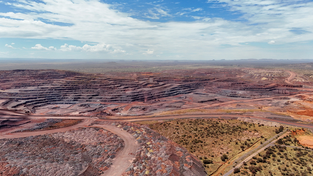 Aerial view of a vast open pit mine its dark terraced layers stark against the reddish brown earth under a wide blue sky Rustenburg North West South Africa. Aerial view of a vast open pit mine its dark terraced layers stark against the reddish brown earth under a wide blue sky Rustenburg North West South Africa.