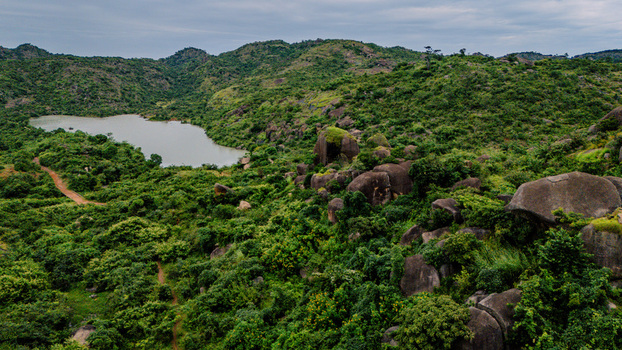 Aerial view of Lamingo Dam surrounded by lush green hills rocky outcrops and dense vegetation under a cloudy sky in Jos Jarawa Plateau Nigeria. Aerial view of Lamingo Dam surrounded by lush green hills rocky outcrops and dense vegetation under a cloudy sky in Jos Jarawa Plateau Nigeria.