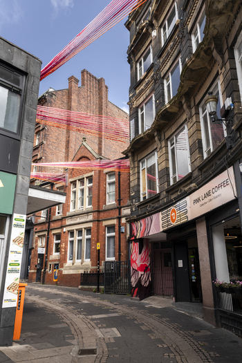 Newcastle upon Tyne United Kingdom 13 July 2026 View of the street scene featuring Pink Lane Coffee a brick Post Office and colorful decorative strings hanging above the road. Newcastle upon Tyne United Kingdom 13 July 2026 View of the street scene featuring Pink Lane Coffee a brick Post Office and colorful decorative strings hanging above the road.