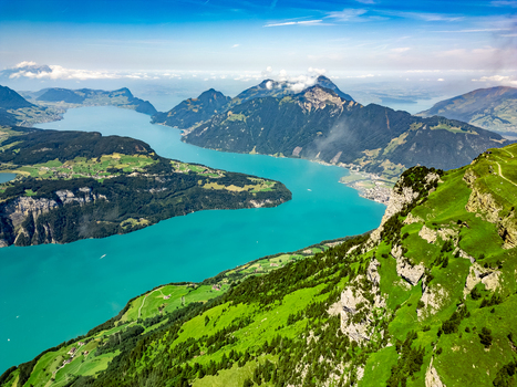 Aerial view of vibrant turquoise waters winding through the majestic Swiss Alps contrasting with the lush green hillsides creating a breathtaking panorama. Stansstad Switzerland. Aerial view of vibrant turquoise waters winding through the majestic Swiss Alps contrasting with the lush green hillsides creating a breathtaking panorama. Stansstad Switzerland.