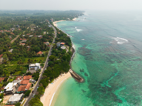 Aerial view of Devil s Rock and the turquoise coastline with sandy beaches and lush tropical greenery in Ahangama Southern Province Sri Lanka. Aerial view of Devil s Rock and the turquoise coastline with sandy beaches and lush tropical greenery in Ahangama Southern Province Sri Lanka.