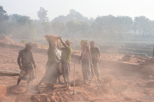 Kushtia District Khulna Division Bangladesh 28 November 2020 View of workers carrying baskets of clay and using shovels in a dusty brickyard. Kushtia District Khulna Division Bangladesh 28 November 2020 View of workers carrying baskets of clay and using shovels in a dusty brickyard.