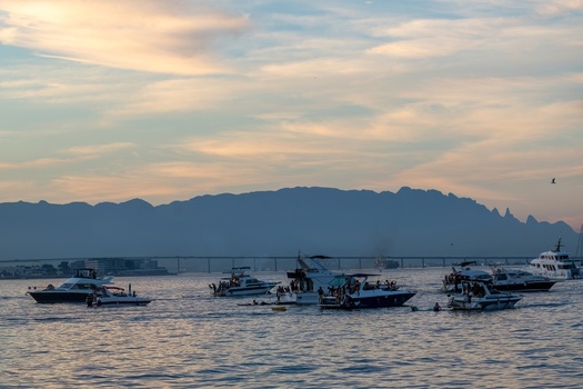 Rio de Janeiro Rio de Janeiro Brazil 20 June 2026 View of Guanabara Bay with motorboats and people at sunset with mountains and a bridge in the background under a soft sky. Rio de Janeiro Rio de Janeiro Brazil 20 June 2026 View of Guanabara Bay with motorboats and people at sunset with mountains and a bridge in the background under a soft sky.