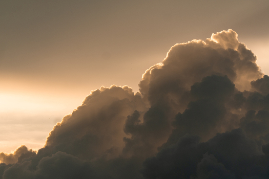 View of dramatic storm clouds illuminated by the warm golden light of sunset over Costa Rica.