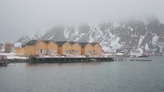 View of yellow houses on stilts in Ballstad Norway.
