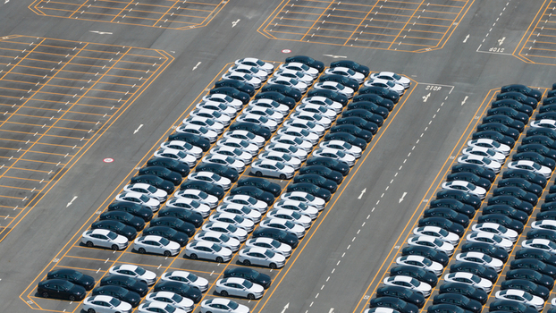 Aerial view of rows of new white and black electric vehicles parked in a large logistics lot at the BYD factory Phananikhom Rayong Thailand.
