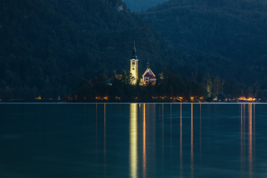 View of Lake Bled with the illuminated Assumption of Mary Church on the island and light reflections on the water at night in Bled Radovljica Slovenia. View of Lake Bled with the illuminated Assumption of Mary Church on the island and light reflections on the water at night in Bled Radovljica Slovenia.