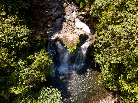 Aerial view of a waterfall cascading over rocks in a lush tropical forest in Banyumas Regency Central Java Indonesia.