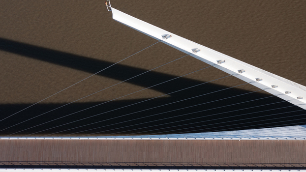 Buenos Aires Argentina 11 July 2022 Aerial view of the Puente de la Mujer in Puerto Madero showing its white mast suspension cables and wooden deck casting a shadow over the water.