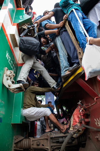 Dhaka Bangladesh 15 June 2018 View of people and commuters climbing onto a crowded train at Airport Railway Station during the Eid al Fitr rush. Dhaka Bangladesh 15 June 2018 View of people and commuters climbing onto a crowded train at Airport Railway Station during the Eid al Fitr rush.