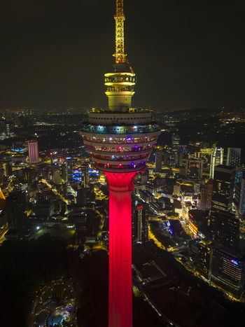 Kuala Lumpur Malaysia 11 March 2026 Aerial view of the illuminated Menara Kuala Lumpur tower at night with the city skyline and urban lights in the background.