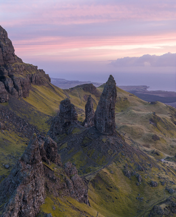 Aerial view of The Storr rock formations and the Old Man of Storr pinnacle under a pink sunset sky on the Isle of Skye Scotland United Kingdom. Aerial view of The Storr rock formations and the Old Man of Storr pinnacle under a pink sunset sky on the Isle of Skye Scotland United Kingdom.
