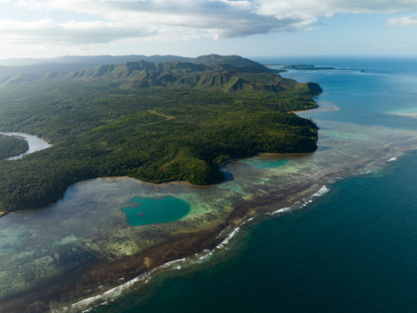 Aerial view of the vibrant coastline where the deep blue ocean meets the lush green forests and winding rivers Goro South Province New Caledonia. Aerial view of the vibrant coastline where the deep blue ocean meets the lush green forests and winding rivers Goro South Province New Caledonia.
