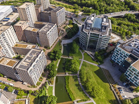 Aerial view of modern residential buildings and office complexes surrounding a canal and green parkland at Lakeside Drive in London England United Kingdom. Aerial view of modern residential buildings and office complexes surrounding a canal and green parkland at Lakeside Drive in London England United Kingdom.