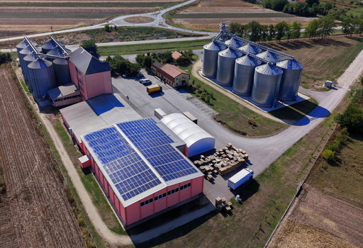 Aerial view of the storage silo Bavaniste facility featuring large metal grain silos a warehouse with solar panels and surrounding agricultural fields in Bavaniste Vojvodina Serbia.