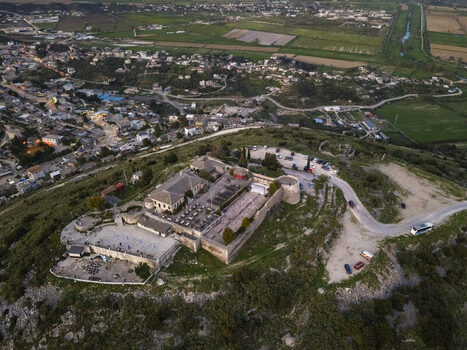 Aerial view of Lekuresi Castle situated on a hilltop overlooking the town of Saranda with stone walls courtyards and surrounding green landscape in Saranda Vlore County Albania. Aerial view of Lekuresi Castle situated on a hilltop overlooking the town of Saranda with stone walls courtyards and surrounding green landscape in Saranda Vlore County Albania.