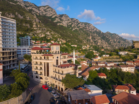 Aerial view of the historic town of Kruje featuring stone architecture a clock tower and a minaret against the backdrop of rugged mountains in Kruje Durres County Albania.