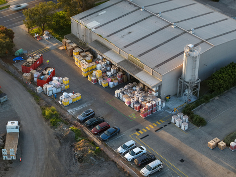 Melbourne VIC Australia 22 September 2026 Aerial view of an industrial factory in Kilsyth with loading docks pallets of goods parked cars and a silo in afternoon light. Melbourne VIC Australia 22 September 2026 Aerial view of an industrial factory in Kilsyth with loading docks pallets of goods parked cars and a silo in afternoon light.