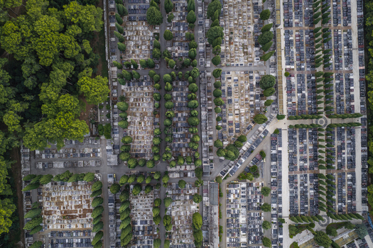 Aerial view of a large cemetery with organized rows of graves stone markers and lush green trees arranged in a grid pattern Pula Istarska zupanija Croatia. Aerial view of a large cemetery with organized rows of graves stone markers and lush green trees arranged in a grid pattern Pula Istarska zupanija Croatia.
