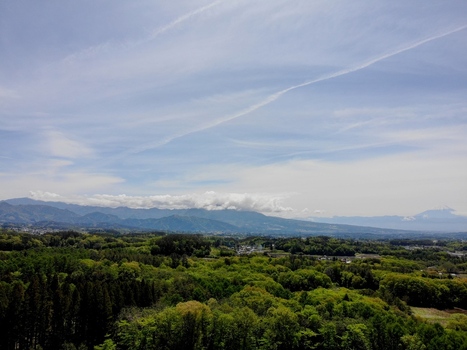 Aerial view of the lush green foothills of the Yatsugatake Mountains with dense forests and distant mountain ranges under a blue sky in Chino Nagano Japan. Aerial view of the lush green foothills of the Yatsugatake Mountains with dense forests and distant mountain ranges under a blue sky in Chino Nagano Japan.