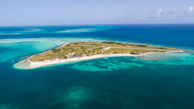 Aerial view of Los Roques archipelago featuring a small island with a landing strip white sandy beaches and turquoise Caribbean waters in Los Roques Dependencias Federales Venezuela. Aerial view of Los Roques archipelago featuring a small island with a landing strip white sandy beaches and turquoise Caribbean waters in Los Roques Dependencias Federales Venezuela.