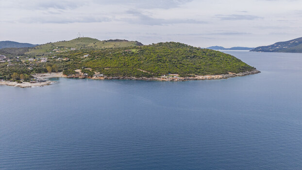 Aerial view of the lush green coastline and rocky shores with clear blue sea and coastal vegetation Ksamil Vlore County Albania. Aerial view of the lush green coastline and rocky shores with clear blue sea and coastal vegetation Ksamil Vlore County Albania.