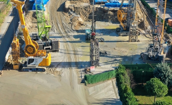 Aerial view of a busy construction site with heavy machinery yellow cranes and earthmoving equipment on a dirt ground Avcilar Istanbul Turkey. Aerial view of a busy construction site with heavy machinery yellow cranes and earthmoving equipment on a dirt ground Avcilar Istanbul Turkey.
