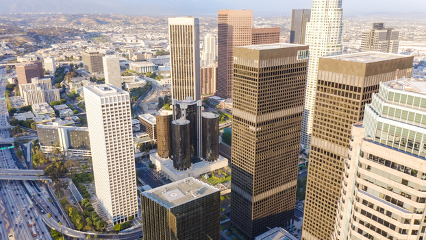 Aerial view of the dense downtown Los Angeles skyline featuring modern skyscrapers glass office towers and a complex highway interchange in Los Angeles California United States.
