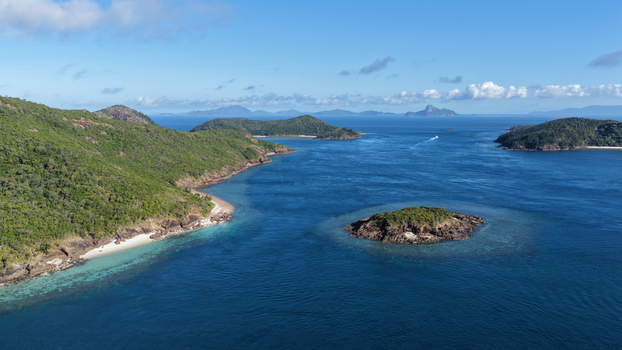 Aerial view of Haslewood Island featuring lush green hills rocky coastlines and turquoise waters in Whitsundays Queensland Australia. Aerial view of Haslewood Island featuring lush green hills rocky coastlines and turquoise waters in Whitsundays Queensland Australia.