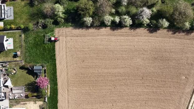 Aerial view of tractor tilling the field France.