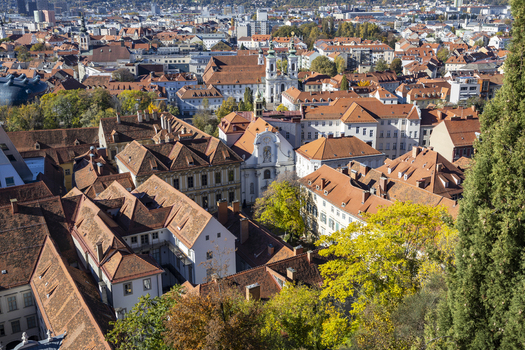 View of the city with aged orange rooftops contrasted by autumnal colored trees showcasing the urban landscape Graz Styria Austria. View of the city with aged orange rooftops contrasted by autumnal colored trees showcasing the urban landscape Graz Styria Austria.