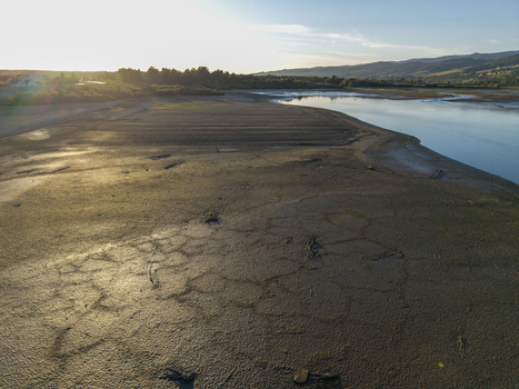 Aerial view of the dried lake bed of Czorsztyn Lake with cracked mud patterns and receding water under the golden hour light in Czorsztyn Lesser Poland Voivode Poland. Aerial view of the dried lake bed of Czorsztyn Lake with cracked mud patterns and receding water under the golden hour light in Czorsztyn Lesser Poland Voivode Poland.