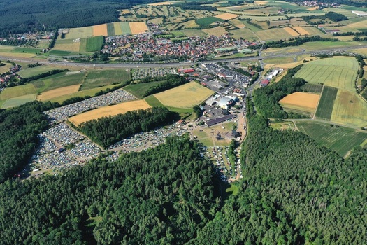 Aerial view of the Eventzentrum Strohofer Geiselwind musichall complex with large parking areas surrounding green forests and agricultural fields in Geiselwind Bayern Germany. Aerial view of the Eventzentrum Strohofer Geiselwind musichall complex with large parking areas surrounding green forests and agricultural fields in Geiselwind Bayern Germany.