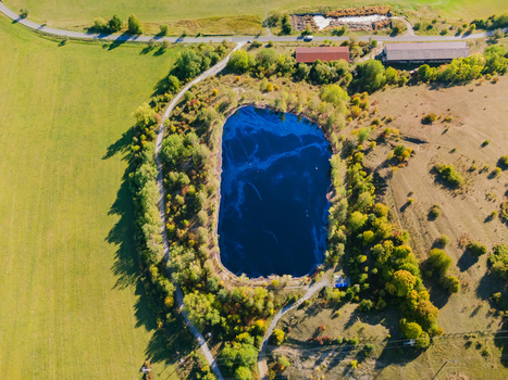 Aerial view of the Gudronove jamy acid tar lagoons surrounded by lush trees and agricultural fields near the Low Tatras mountains in Predajna Banskobystricky kraj Slovakia. Aerial view of the Gudronove jamy acid tar lagoons surrounded by lush trees and agricultural fields near the Low Tatras mountains in Predajna Banskobystricky kraj Slovakia.