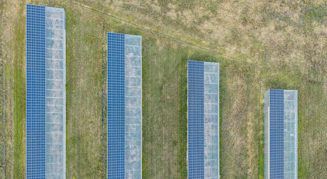 Aerial view of modern agricultural greenhouses with rooftop solar panels illustrating agrivoltaic infrastructure and sustainable farming in Loriol sur Drome Auvergne Rhone Alpes France.