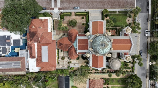 Aerial view of Memorial Presbyterian Church featuring its distinctive copper dome red tile roofs and surrounding landscaped courtyards in St. Augustine Florida United States.