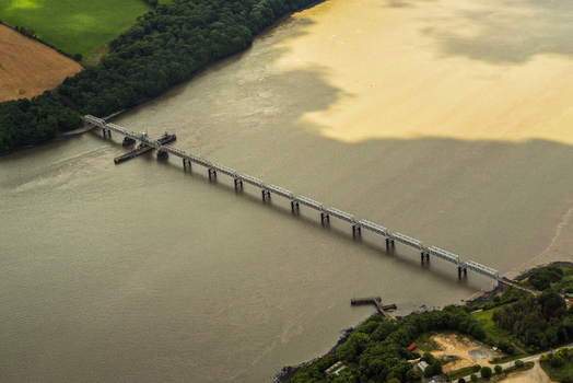 Aerial view of Barrow Bridge spanning the River Barrow between lush green fields and dense forests in Wexford County Wexford Ireland.