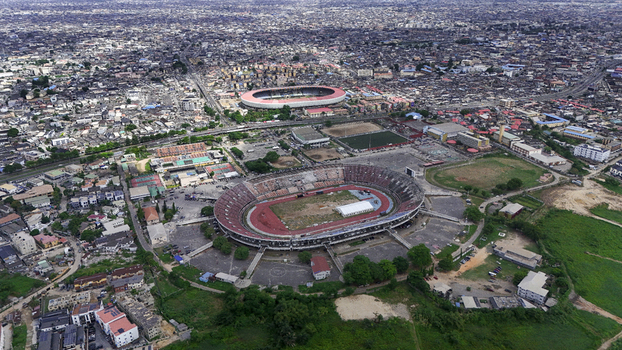 Aerial view of the National Stadium Surulere and Teslim Balogun Stadium surrounded by the dense urban landscape and residential rooftops in Lagos Lagos Nigeria.