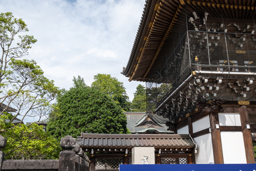 View of a traditional Japanese temple structure with dark tiled roofs contrasting against the bright sky and lush greenery Narita Chiba Japan. View of a traditional Japanese temple structure with dark tiled roofs contrasting against the bright sky and lush greenery Narita Chiba Japan.