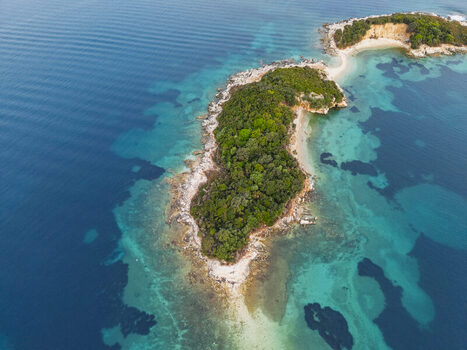 Aerial view of the Ksamil islands surrounded by turquoise waters and lush greenery in Ksamil Vlore County Albania. Aerial view of the Ksamil islands surrounded by turquoise waters and lush greenery in Ksamil Vlore County Albania.