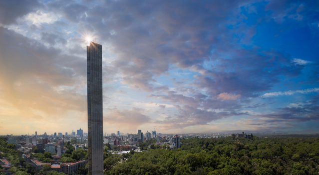 Aerial view of the slender Torre Reforma skyscraper with a sun flare overlooking the lush Chapultepec park and urban skyline under a cloudy sky in Mexico City Mexico City Mexico.