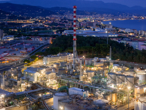 Aerial view of the plant for the production of finished lubricants illuminated at night with industrial tanks piping and a tall chimney in Vado Ligure Liguria Italy. Aerial view of the plant for the production of finished lubricants illuminated at night with industrial tanks piping and a tall chimney in Vado Ligure Liguria Italy.