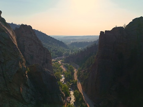 Aerial view of Eldorado Canyon with towering red rock cliffs a winding road and a stream flowing through the valley in Eldorado Springs Colorado United States.