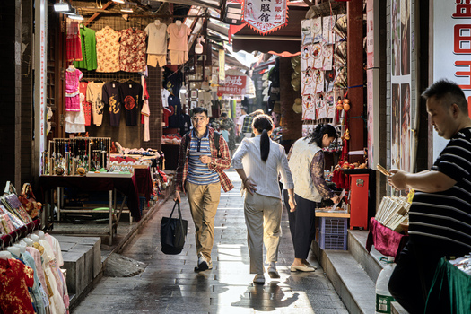 Xi an Shaanxi China 14 September 2026 View of people walking through a bustling street market lined with traditional shops and stalls in the historic Muslim Quarter.