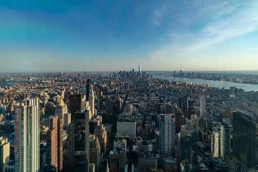 New York United States 09 August 2021 Aerial view of the Manhattan skyline featuring One World Trade Center dense urban architecture and the Hudson River under clear skies.