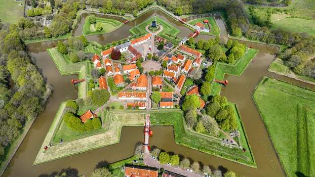 Aerial view of the star shaped Fort Bourtange with historic red roofed houses and green ramparts surrounded by water moats in Bourtange Groningen Netherlands. Aerial view of the star shaped Fort Bourtange with historic red roofed houses and green ramparts surrounded by water moats in Bourtange Groningen Netherlands.