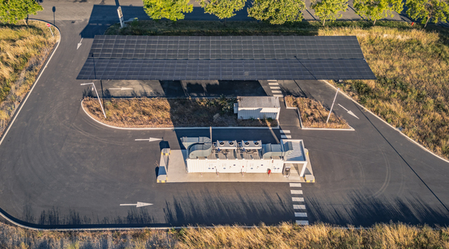 Aerial view of a battery energy storage system integrated with a solar photovoltaic carport featuring storage containers in Le Pouzin Auvergne Rhone Alpes France. Aerial view of a battery energy storage system integrated with a solar photovoltaic carport featuring storage containers in Le Pouzin Auvergne Rhone Alpes France.