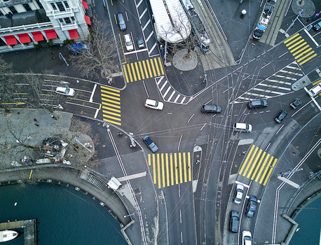 Aerial view of a busy intersection with tram tracks pedestrian crossings and cars in the city center of Zurich Zurich Switzerland. Aerial view of a busy intersection with tram tracks pedestrian crossings and cars in the city center of Zurich Zurich Switzerland.